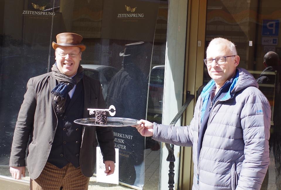 Rainer Nehlig übergibt die Schlüssel an Dr. Andreas Thelen (links) - in Zeiten von Corona mit Tablett und auf Distanz Foto: Duo Zeitensprung